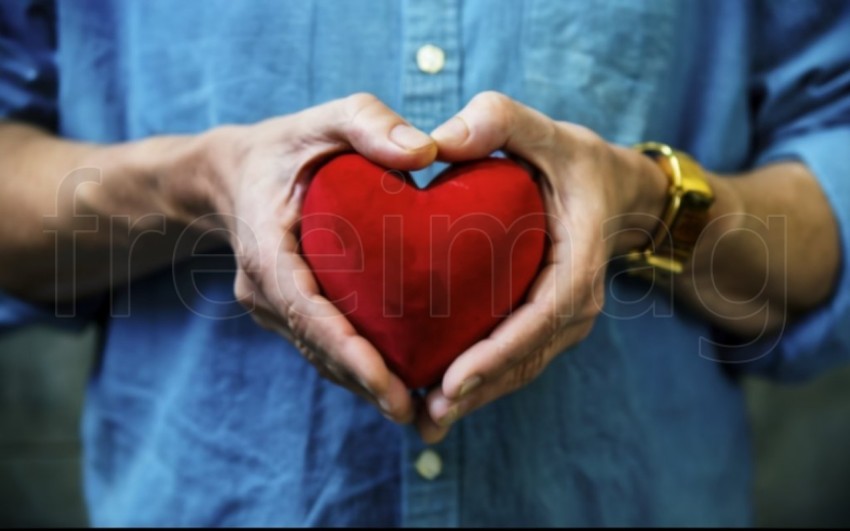 Dos manos  sostienen un corazón rojo sobre un fondo azul