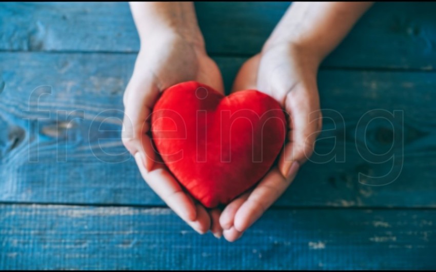 Dos manos  sostienen un corazón rojo sobre un fondo azul