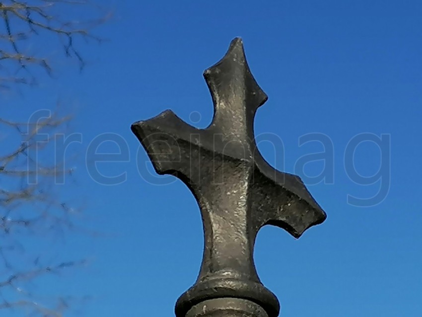 Cruz gris fondo cielo azul