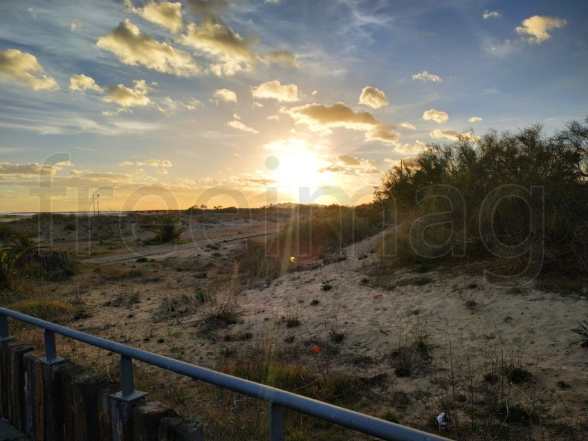 Playa de mar con puesta de sol