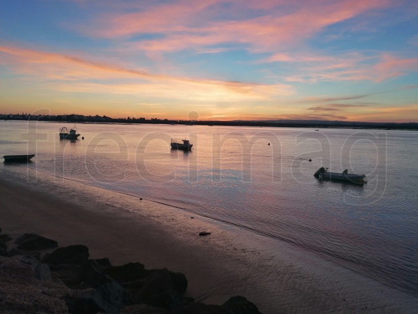 Puesta de sol con barcos sobre él mar