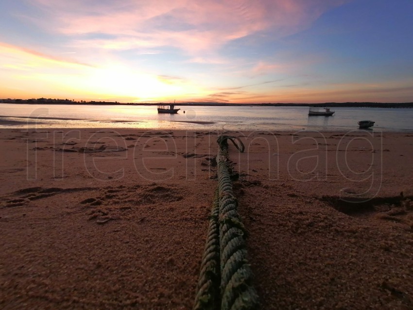 Puesta de sol con barcos sobre el mar