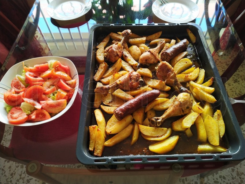 Muslos de pollo al horno con patatas en rodajas y chorizo