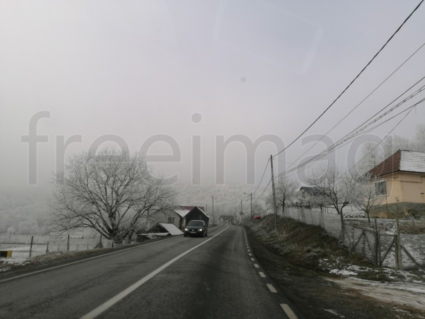 Carretera solitaria en un bosque nevado en Transilvania, Rumanía